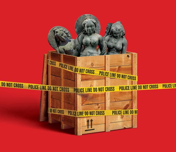 three ancient sculptures inside crate draped with yellow police tape