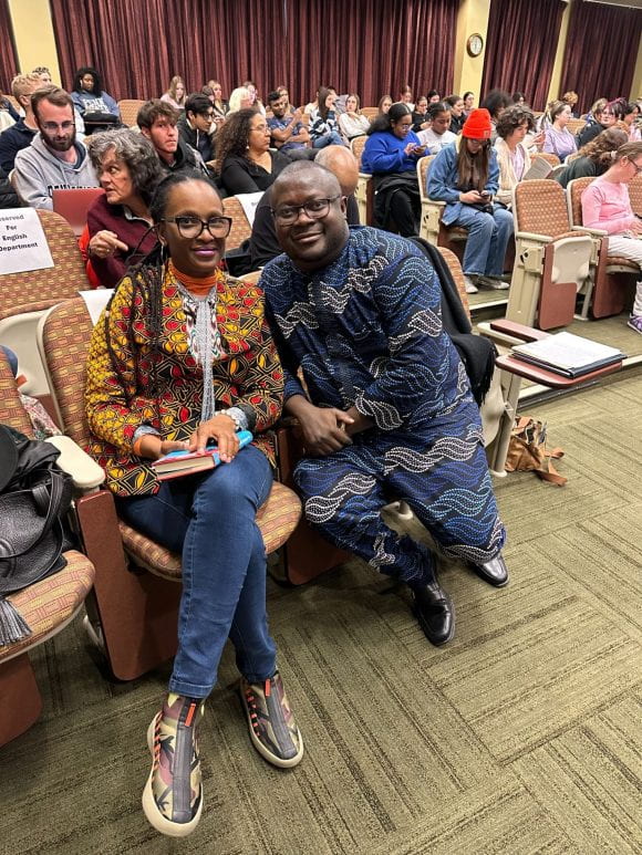 Visiting writer Chika Unigwe and Penn State writing professor Samuel Kolawole seated before reading, with full audience in background.